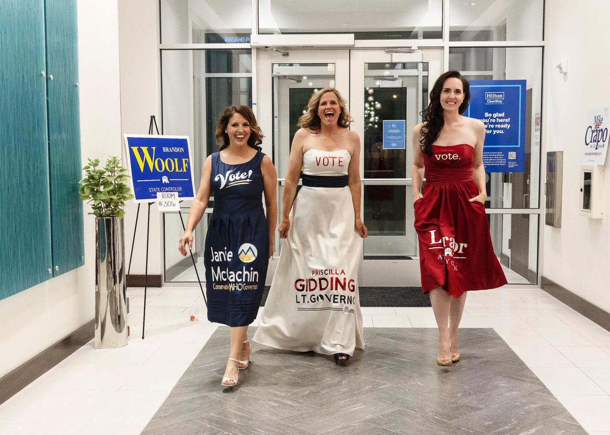 Sara Brady, right, walks through the lobby of the Hilton Garden Inn Boise Downtown at a GOP primary election- night watch party on May 17, 2022. Brady wore a dress with Raúl Labrador’s campaign logo.