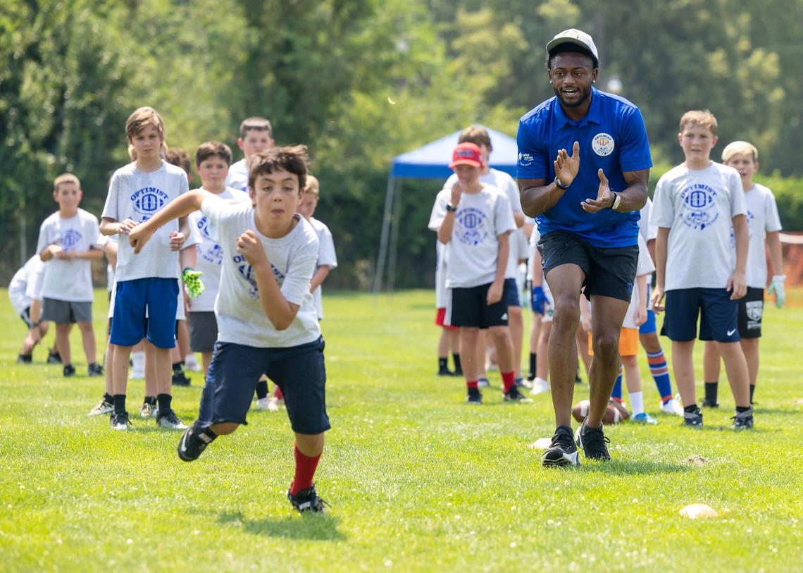 Boise State cornerback Markel Reed encourages kids participating in a drill at the Optimist Youth Football Kids Skills Camp on Saturday in Boise.