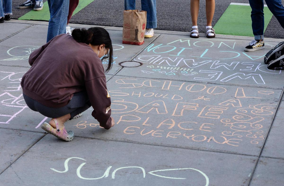 Messages promoting safe schools and gun control are written in chalk on the sidewalk in from of the Idaho Capitol during a vigil held for the people killed in the Uvalde school shooting.