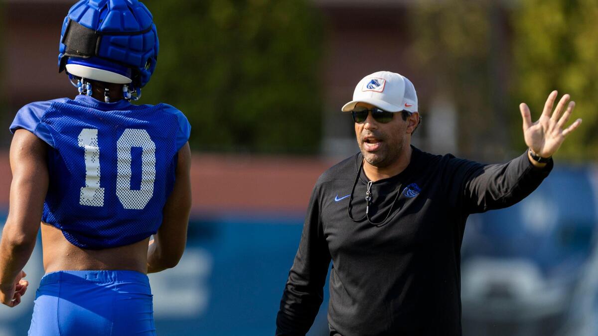 Boise State offensive coordinator and quarterbacks coach Bush Hamdan talks to quarterback Taylen Green during the Broncos’ fall camp.