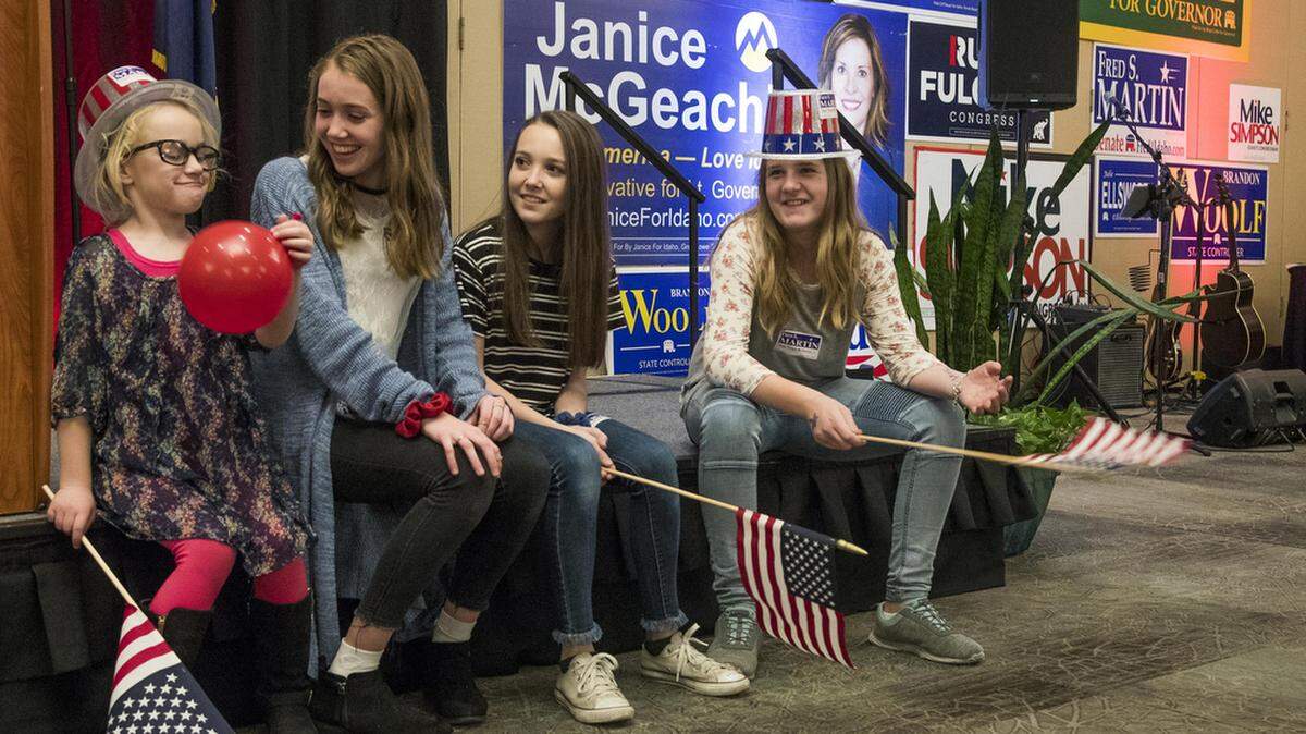 Oaklee Swenson, 5, left, of Mountain Home; Suzanna Farris, 15, Makenna Farris, 13, both of Boise; and Lainee Martin, 11, of Rupert, get into a festive mood with balloons, hats and flags at the Idaho Republican election night party Tuesday, Nov. 6, 2018 at the Riverside Hotel in Garden City.