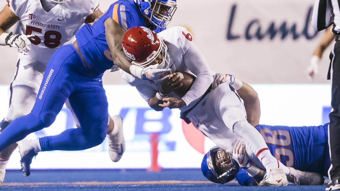 Boise State middle linebacker Tyson Maeva (58) and STUD Jabril Frazier (8) sack Fresno State quarterback Marcus McMaryion in the fourth quarter Nov. 9 at Albertsons Stadium in Boise.