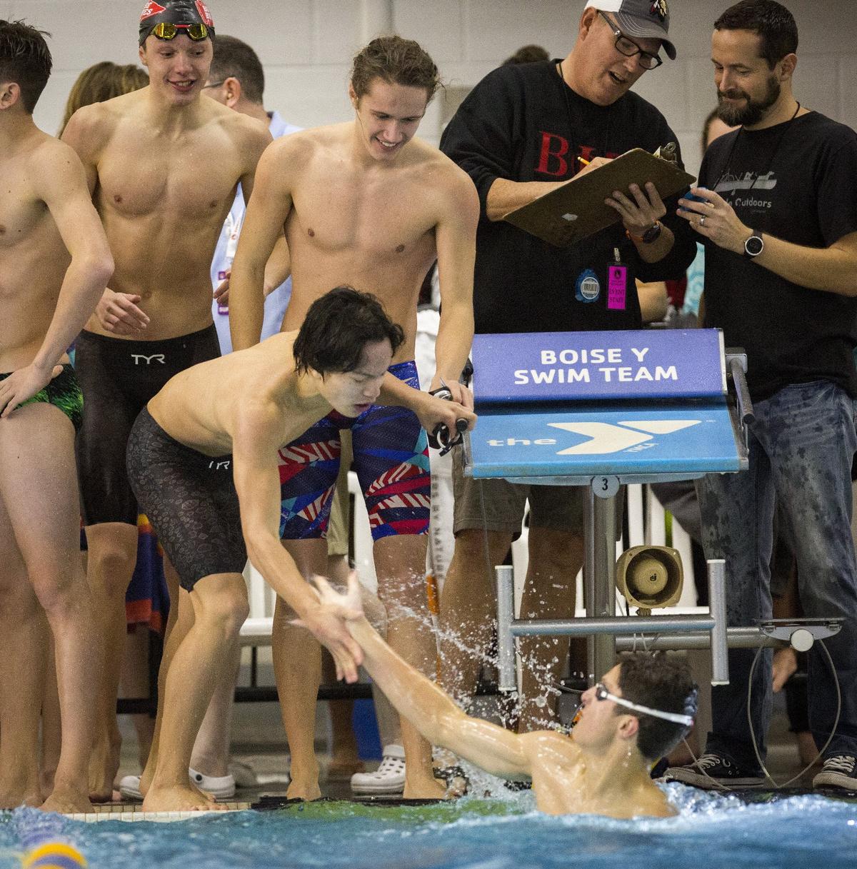 Timothy Wong congratulates anchor swimmer Nathan Quarterman as Boise finishes first in the 400-yard freestyle relay on the final day of the 5A state swimming championships at the West Boise YMCA.
