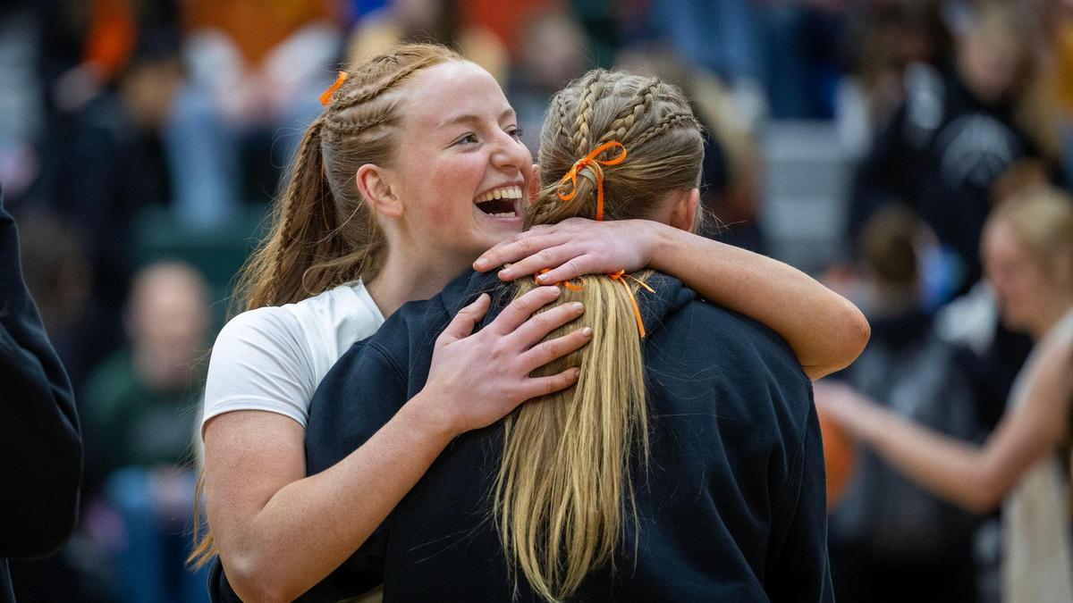 Eagle junior Audrey Baxter hugs a friend during a home basketball game. Baxter lost her mother to acute myeloid leukemia last March. The Mustangs held a Leukemia Awareness Night in honor of the Baxter family.