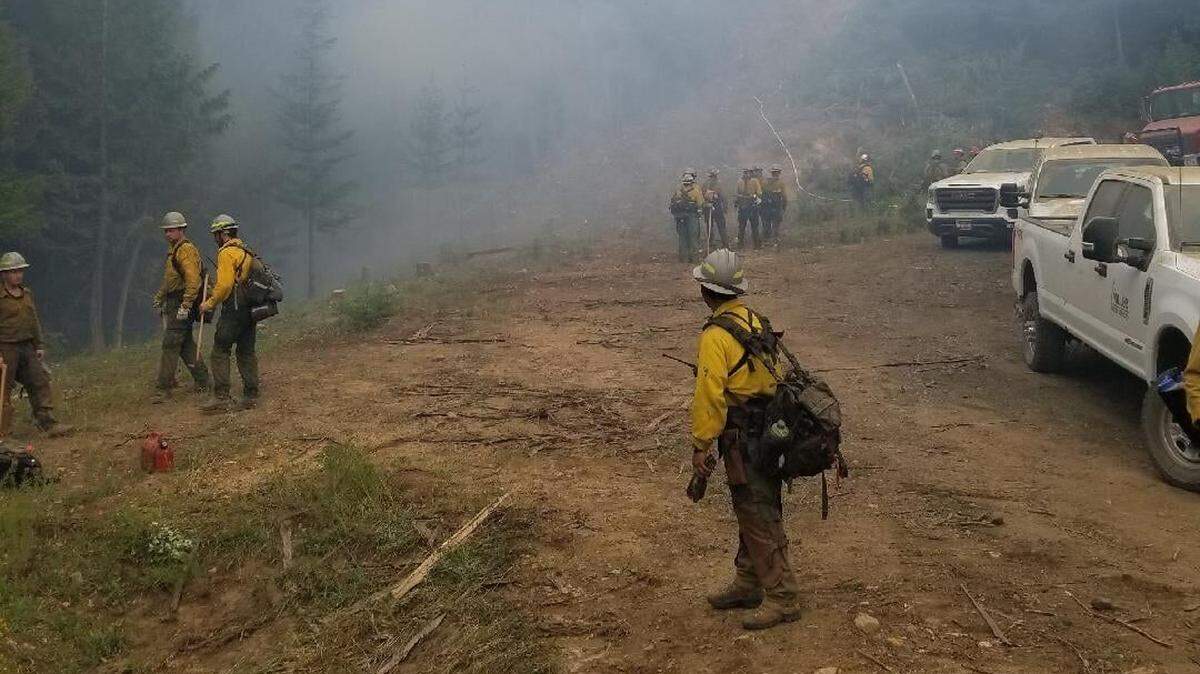 Firefighters work on the Johnson Creek Fire near Elk River, Idaho, in July 2021. An Idaho man is facing a $34,000 fine from the Federal Communications Commission after he allegedly interfered with radio communications during the wildfire.