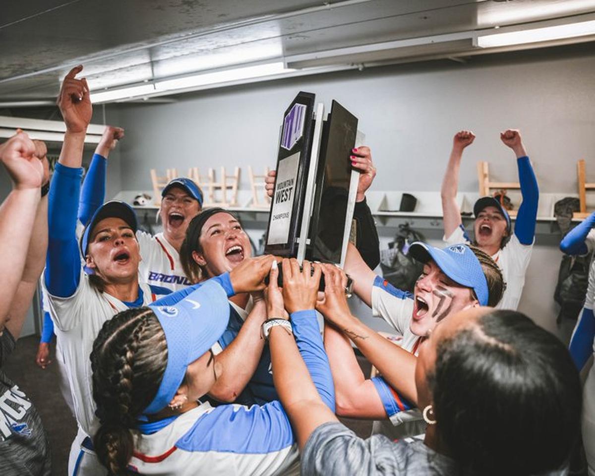 The Boise State softball team celebrates with the regular season Mountain West trophy after a 3-0 win at Fresno State on Friday.