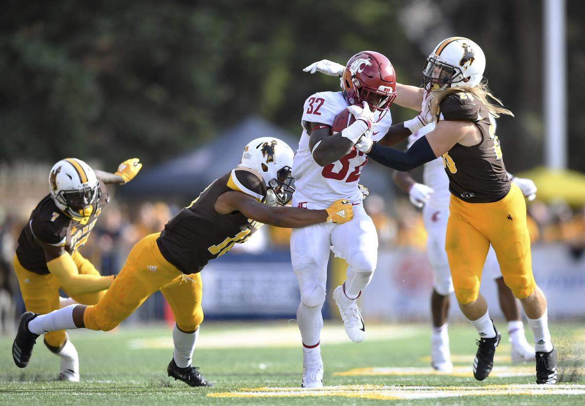 Washington State running back James Williams (32) carries against Wyoming as safety Andrew Wingard (right) tries to make a stop Sept. 1 in Laramie, Wyo.