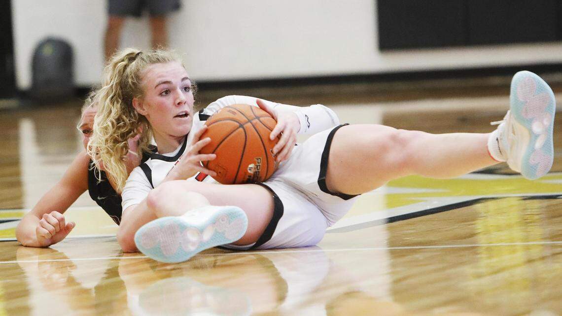Boise’s Avery Howell swipes a loose ball away from Rigby’s Kylie Dansie in the 5A girls basketball state tournament third-place game Saturday at Bishop Kelly.