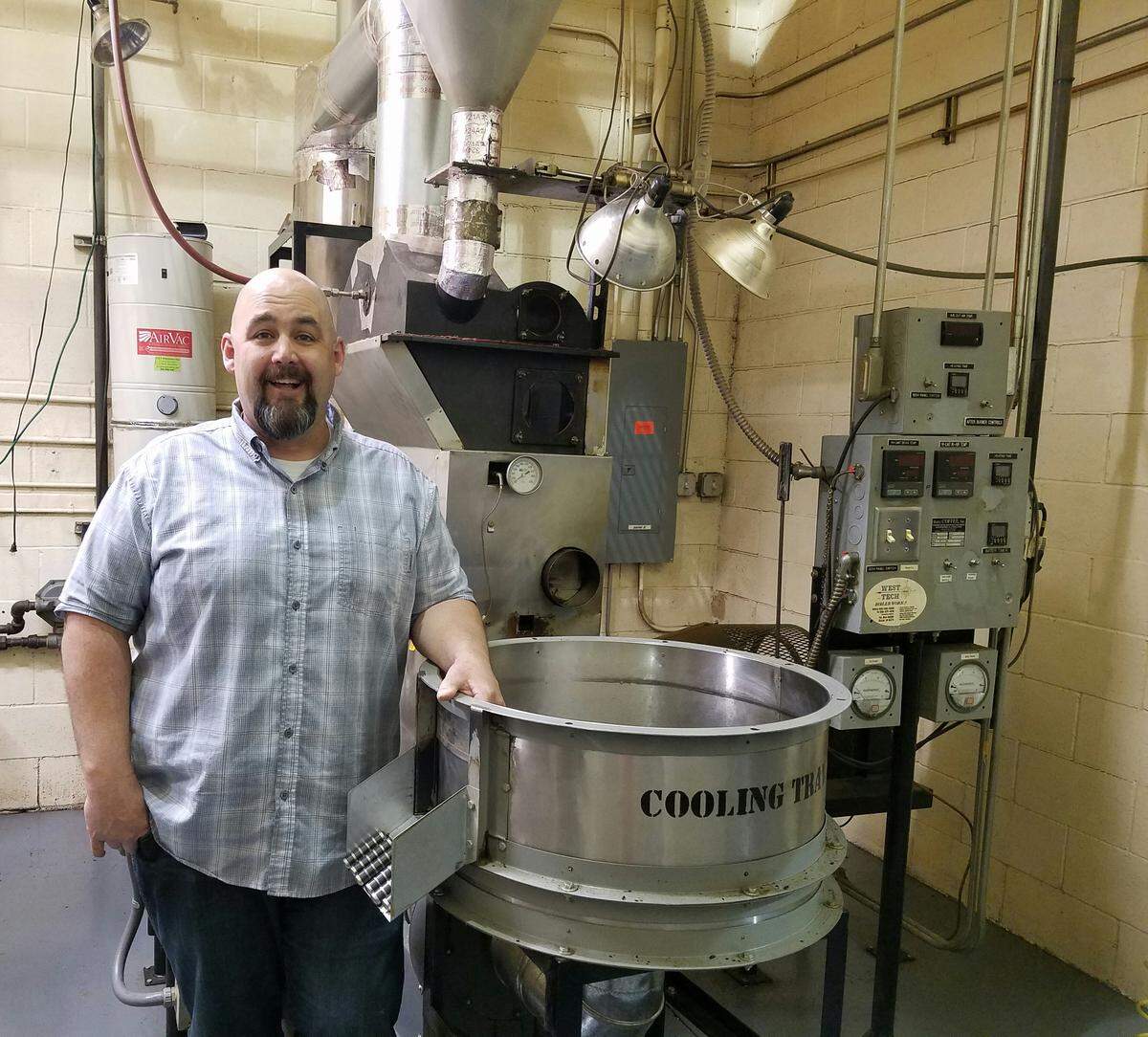 Ryan Stewart, co-owner of Moxie Java, stands in front of the company’s coffee air roaster. It operates almost like an air popcorn popper, Stewart said, keeping the beans suspended in air while hot air roasts them.