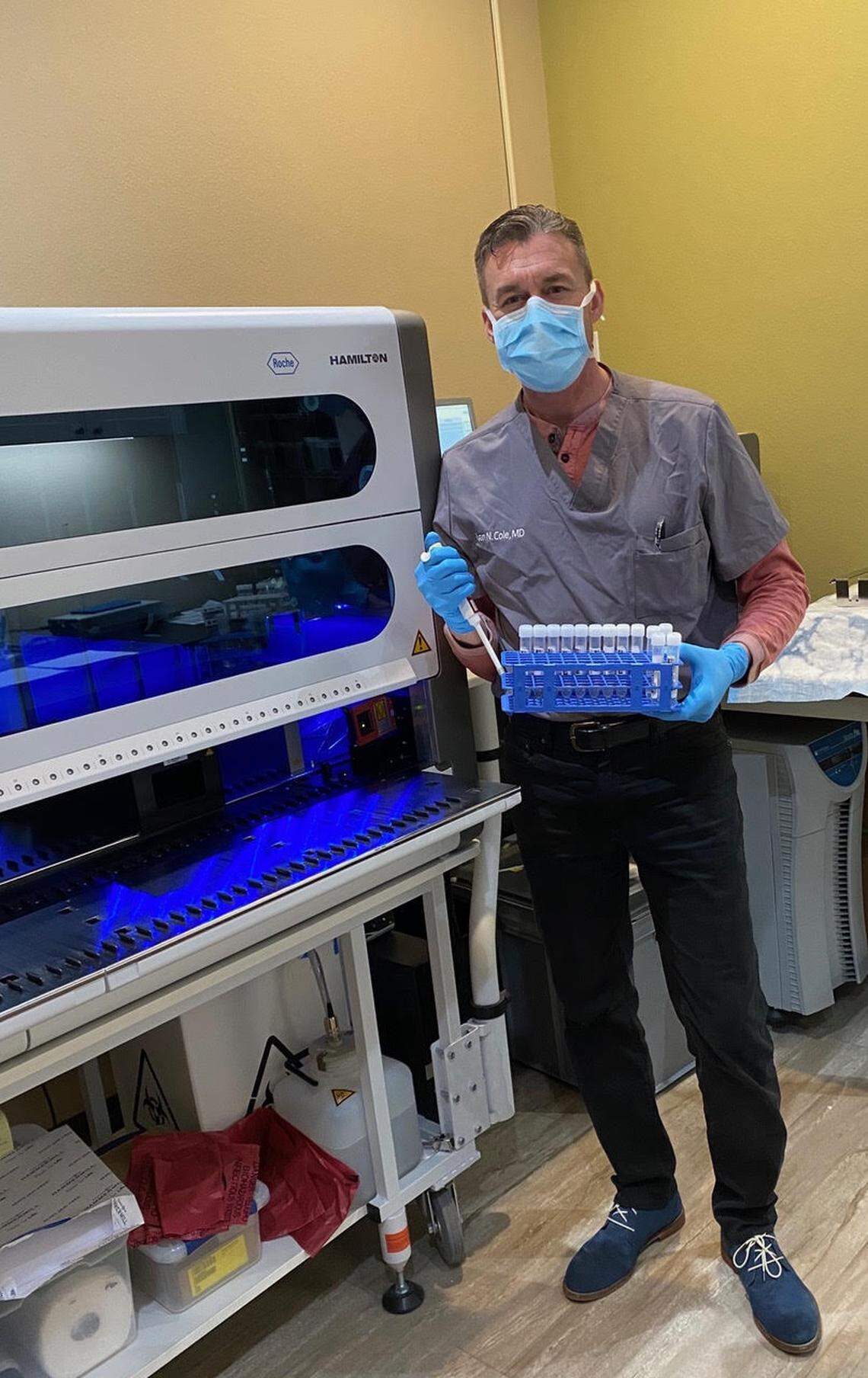 Dr. Ryan Cole, CEO and medical director of Cole Diagnostics, posing in his lab with the COVID-19 testing machine manufactured by Roche Diagnostic Corp. during the early days of the pandemic.