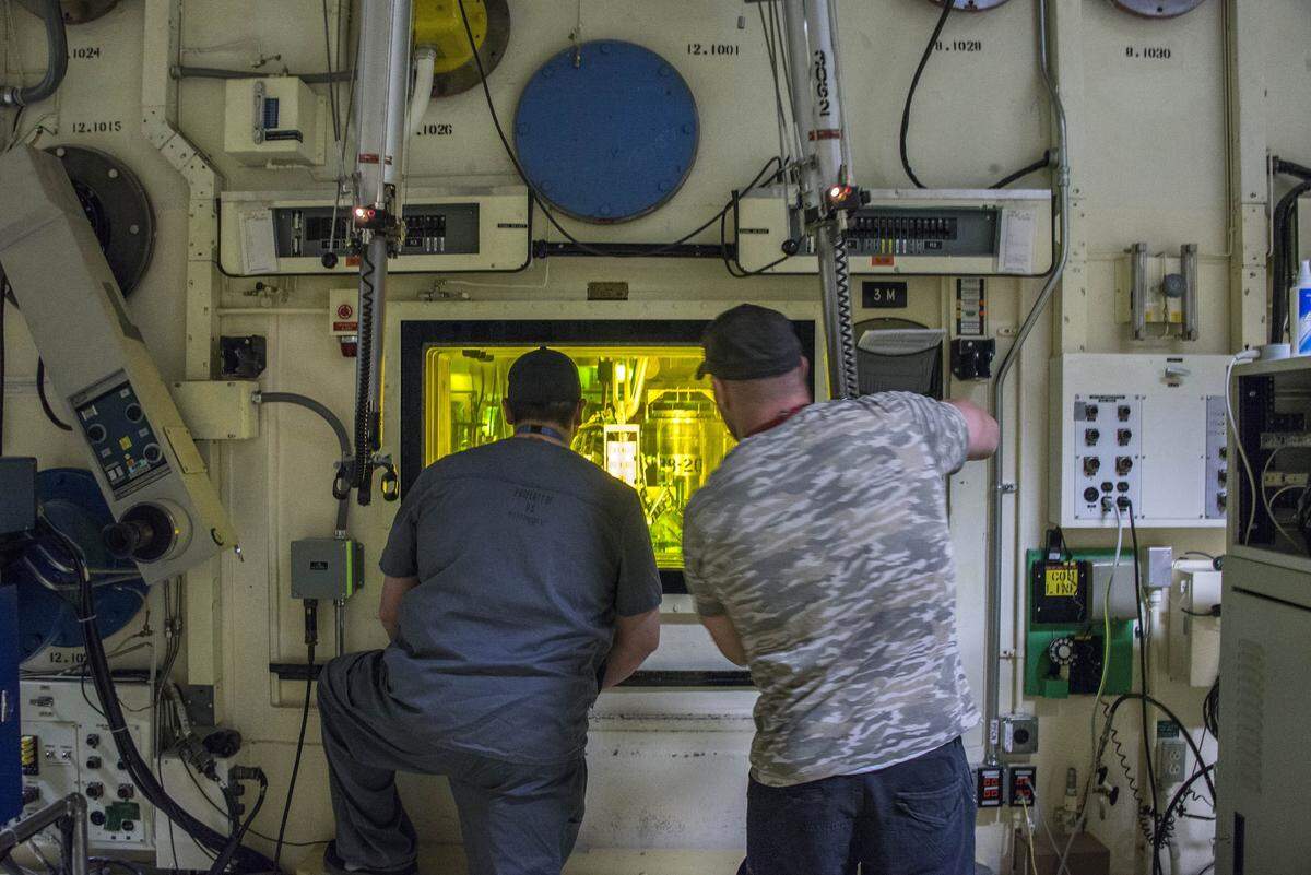 From left, Freddy Rodriguez and Brian Simmons, process nuclear operators at Idaho National Laboratory, use master-slave manipulators to work with radioactive material on the other side of the glass. In addition to nuclear research, the INL site houses decades-long efforts to remove and ship out of Idaho nuclear and contaminated waste buried in the desert between Idaho Falls and Arco.