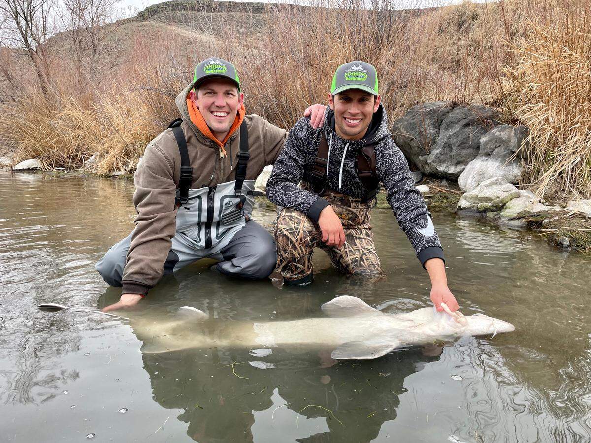 Randal Clayton and fishing columnist Jordan Rodriguez show off a six-foot white sturgeon caught on a trip with Captain Tim Parrish of Hammett Valley Fishing Adventures.