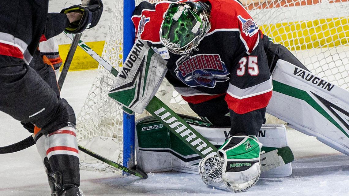 Idaho Steelheads goalie Adam Scheel traps the puck between his knee pad and the goal frame as the play is whistled dead, and before Kansas City’s Joshua Lammon forces it into the goal, Wednesday, March 29, 2023, at Idaho Central Arena in downtown Boise.