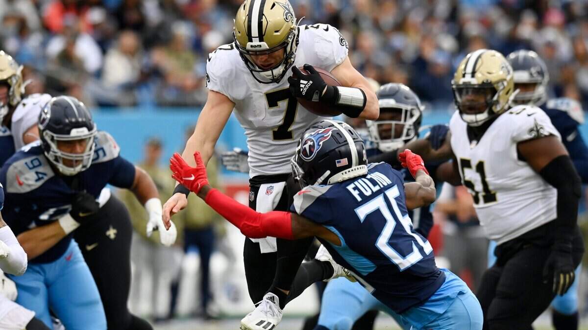New Orleans Saints quarterback Taysom Hill tries to leap past Titans cornerback Kristian Fulton on Nov. 14 in Nashville, Tennessee. Hill, a graduate of Highland High School in Pocatello, recently signed a new four-year contract with the Saints.