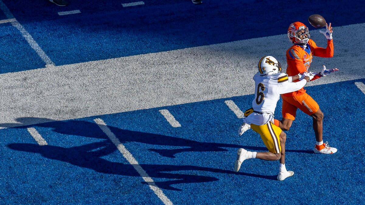 Boise State wide receiver Eric McAlister catches a 49-yard touchdown pass defended by Wyoming cornerback Kolbey Taylor in the first quarter Saturday at Albertsons Stadium.