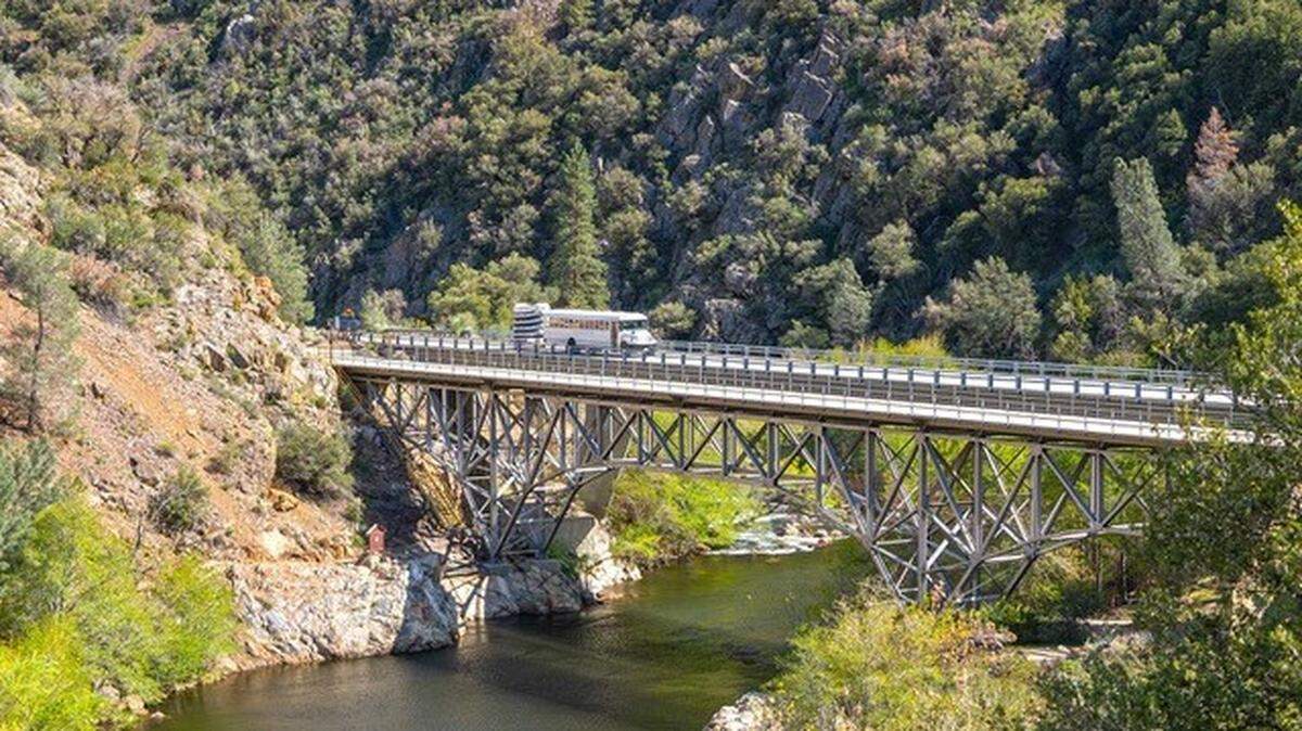 A Caldwell Transportation Company bus towing rafts crosses a bridge over the Salmon River in Idaho.
