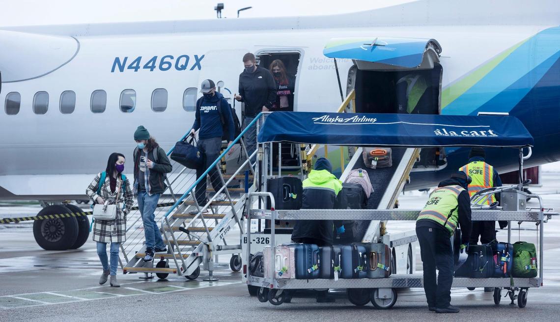 Passengers exit an Alaska Airlines flight as crews work to unload luggage at the Boise Airport in January 2022.