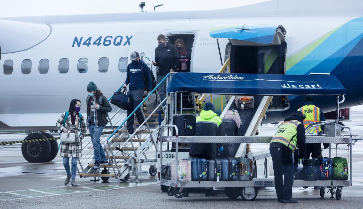 Passengers exit an Alaska Airlines flight as crews work to unload luggage at the Boise Airport in January 2022.