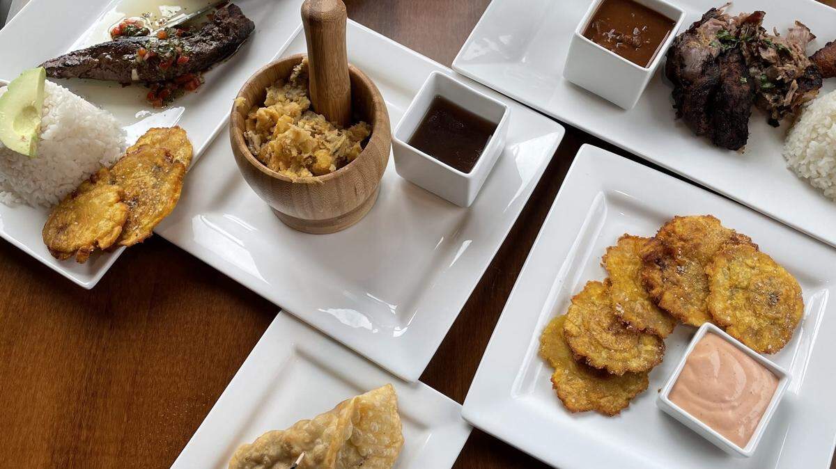 There are plenty of Puerto Rican foods to sample at Wepa Cafe, which opened this year in Garden City. The meat and plantain dishes are stars: churrasco, a cut of flank steak (top left); pernil, which is chopped pork (top right); tostones, which are fried green plantains (bottom right); pastelillo, a beef-filled turnover (bottom left); and mofongo, a mash of green plantains, garlic and pork rind (center).