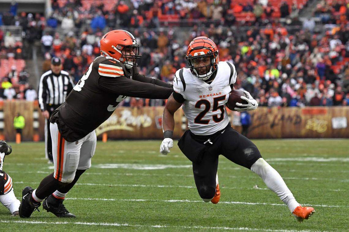 Cincinnati Bengals running back Chris Evans, right, carries the ball as he is hit by Cleveland Browns defensive tackle Tommy Togiai, who is a Highland High graduate.