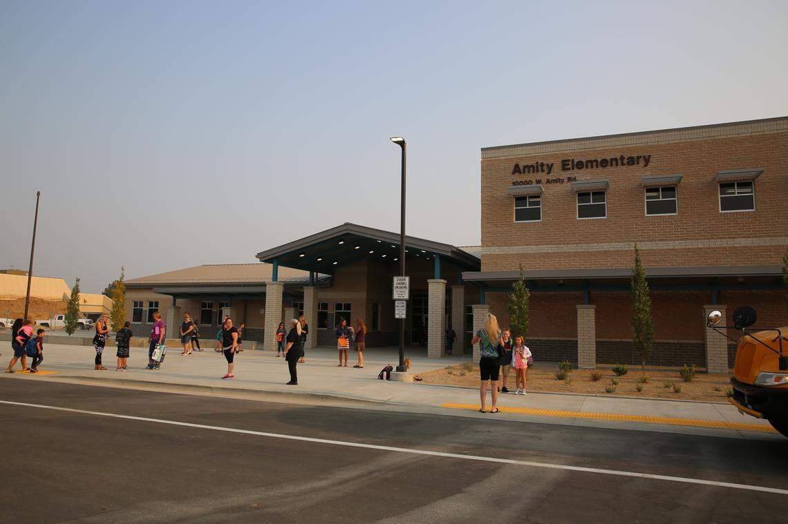 Students stand outside the new Amity Elementary School. The former school building was built in 1979 and featured solar panels to heat and cool and had grass growing on the roof. The innovative approach didn’t work very well, as the roof leaked after every storm and the solar panels failed a year after the school opened. The new school was built in a more conventional style.