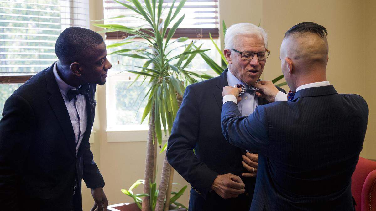 Steve Silva and business partner David McKinzie, left, fit Bob Kustra with a Boise State bow tie. The two entrepreneurs, who met at Boise State's business college, talked with the outgoing president about his legacy.