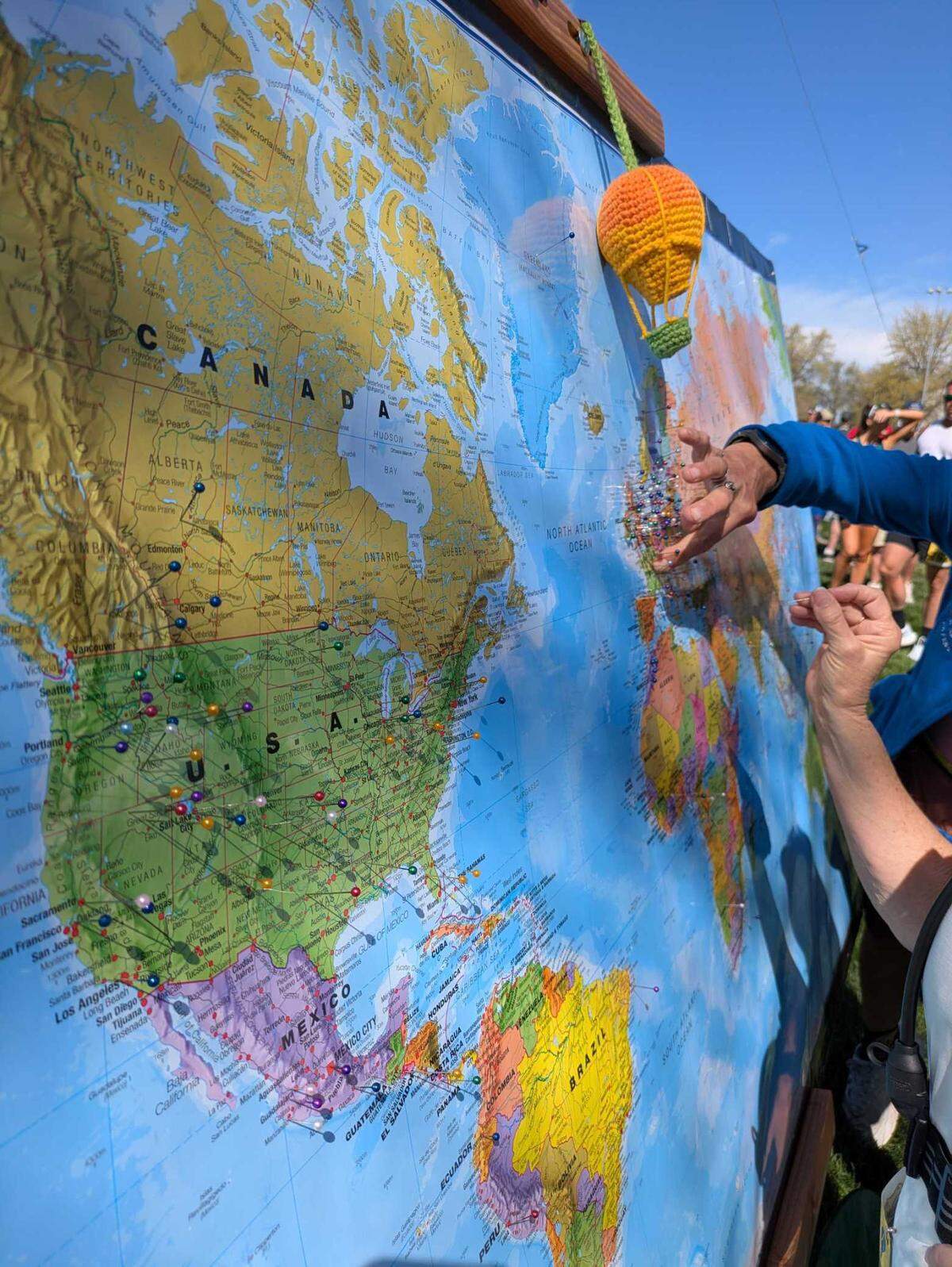 Participants in Saturday’s Race to Robie Creek place pins on a map to show their family’s geographic history before the start of the race at Fort Boise Park. The theme of the event was Around The World in 13.1 miles.