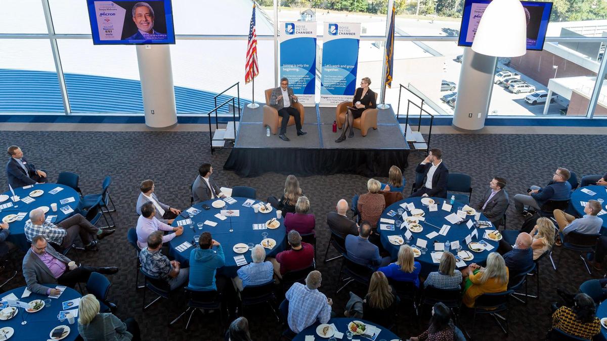 Micron CEO Sanjay Mehrotra, left, addresses a question from Boise State University President Marlene Tromp, right, during a Boise Metro Chamber of Commerce luncheon on Wednesday at the Stueckle Sky Center.