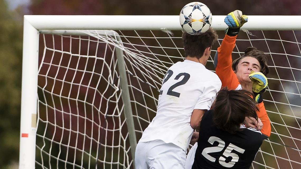 Rocky Mountain keeper Jonah Peterson punches a shot at goal over the heads of Timberline senior Kyle Wright (22) and Rocky teammate Isaac Zutch (25) during the 5A District Three boys soccer championship Oct. 10 at Mountain View High School in Meridian.