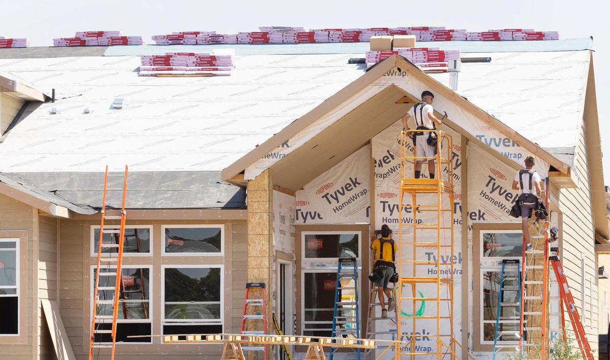 Contractors work on a home under construction in a new community called Pinnacle in South Meridian in early August.