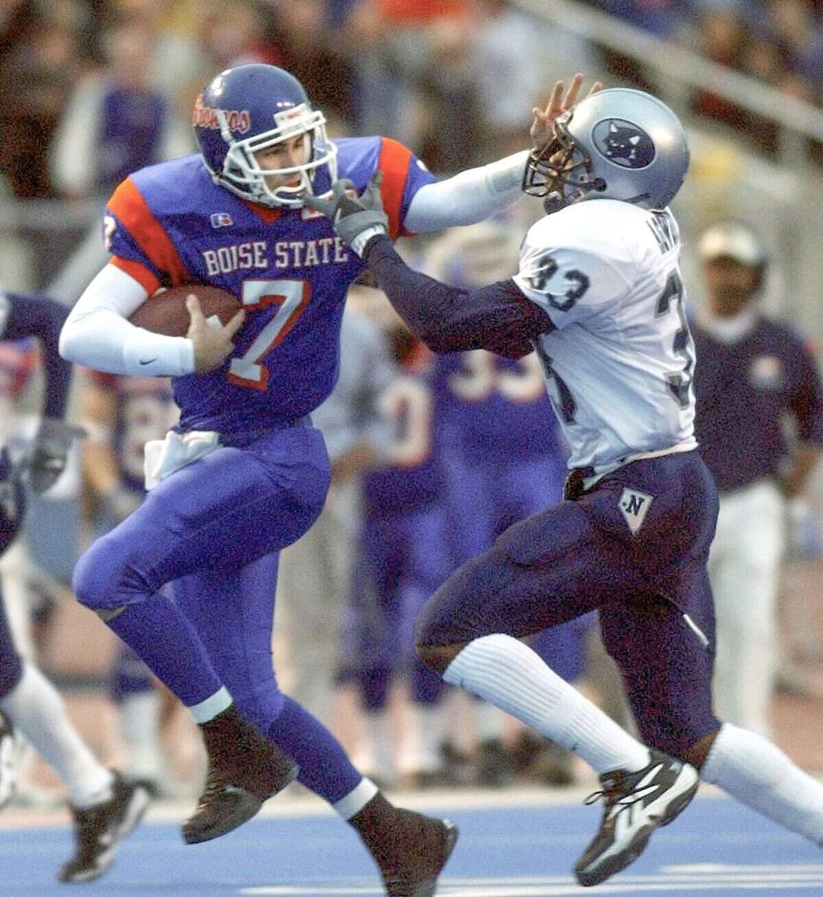 Boise State quarterback Ryan Dinwiddie stiff-arms Nevada's Ekene Agwuenu during the Broncos' 49-7 victory Saturday at Bronco Stadium. The Broncos handed Nevada coach Chris Tormey his first loss as a coach on the blue turf. Oct. 28, 2001.