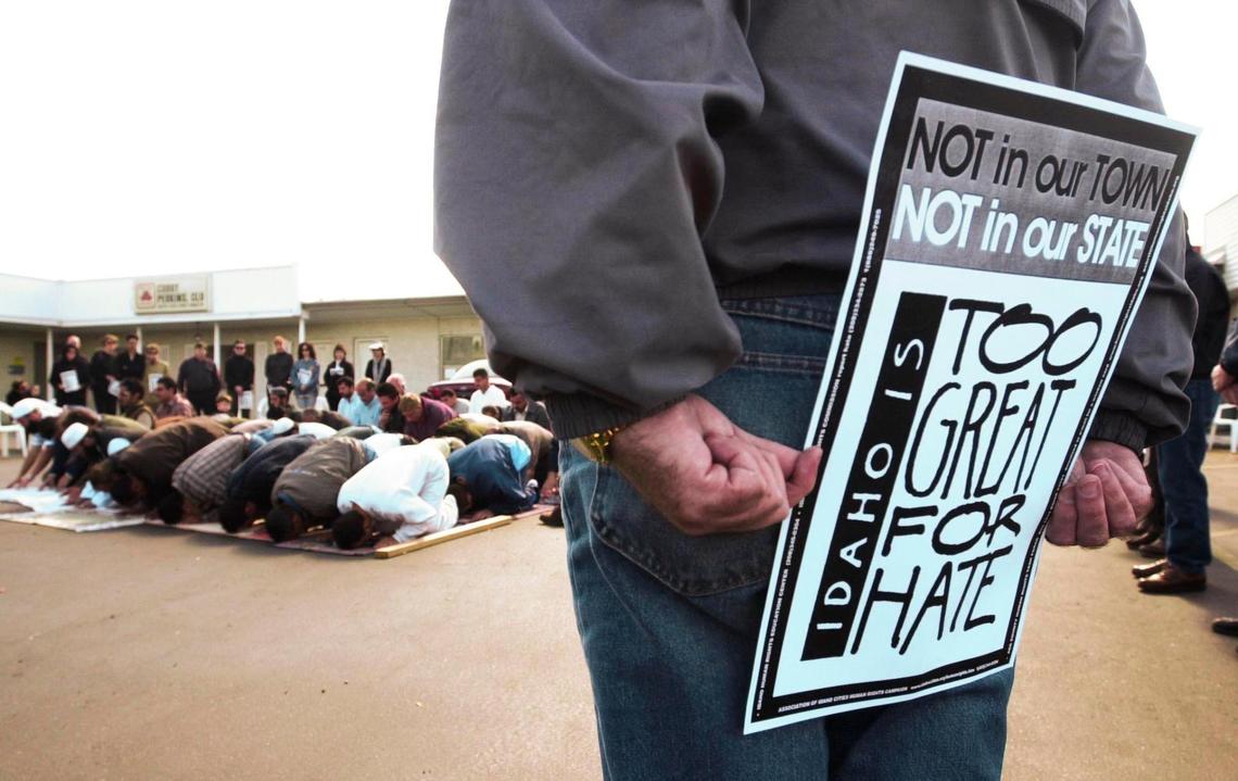 Rick Holm, of Boise, holds a sign Friday, Oct. 12, 2002, as members of the Muslim community hold a prayer service in the parking lot of the Islamic Center. About 70 people formed a circle around the service, something that happened frequently after 9/11.