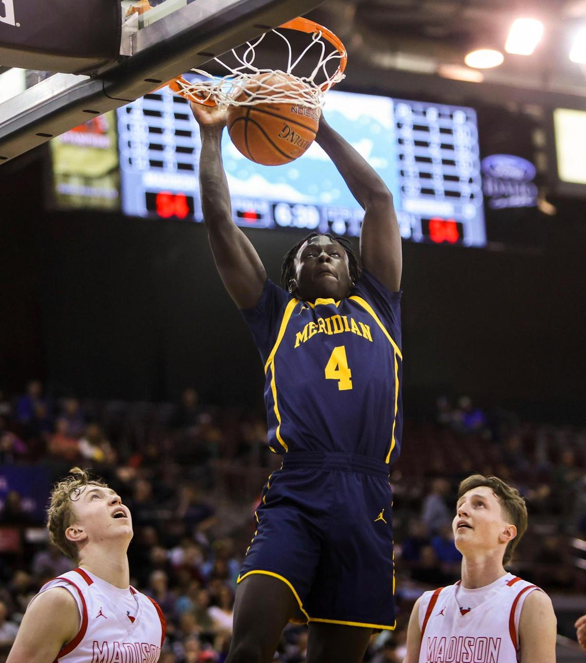 Meridian senior Ladu Kaden throws down a two-handed dunk against Madison in the first round of the 5A boys basketball state tournament Thursday at the Ford Idaho Center in Nampa.