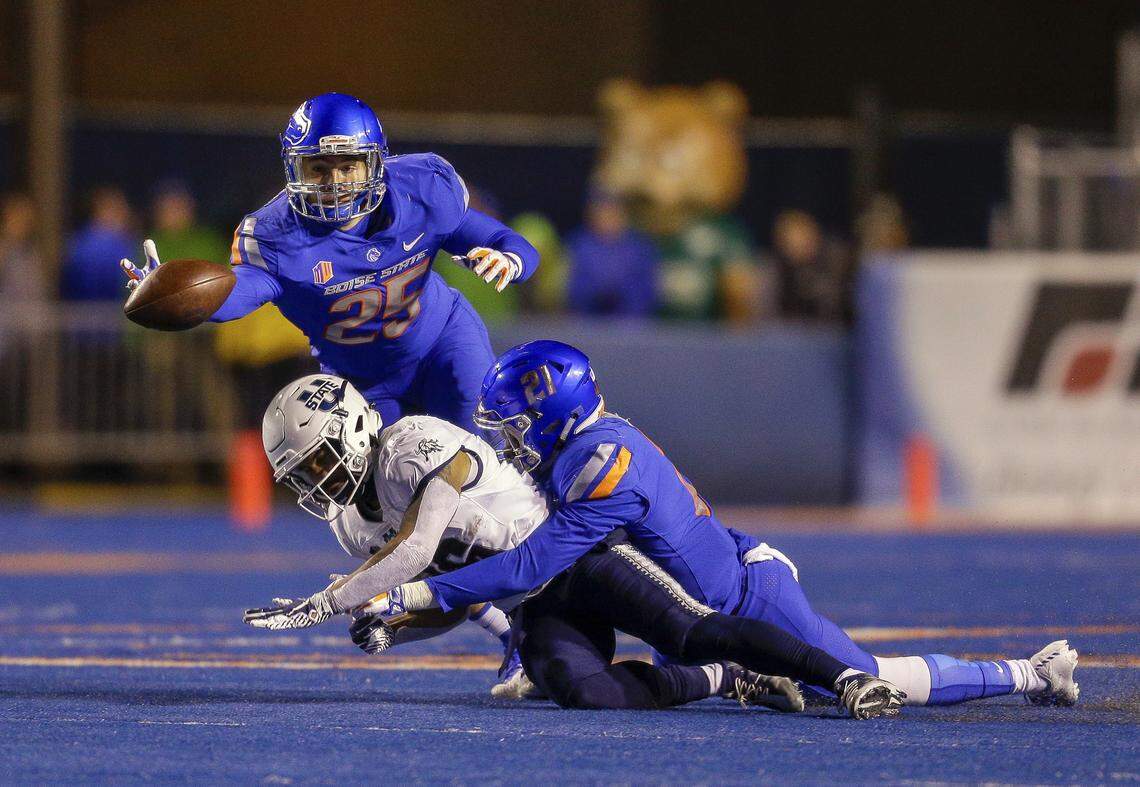 Boise State linebacker Benton Wickersham, top, dives for the ball after Boise State safety Tyreque Jones, right, broke up a pass to Utah State wide receiver Jordan Nathan on Nov. 24, 2018, at Albertsons Stadium in Boise.