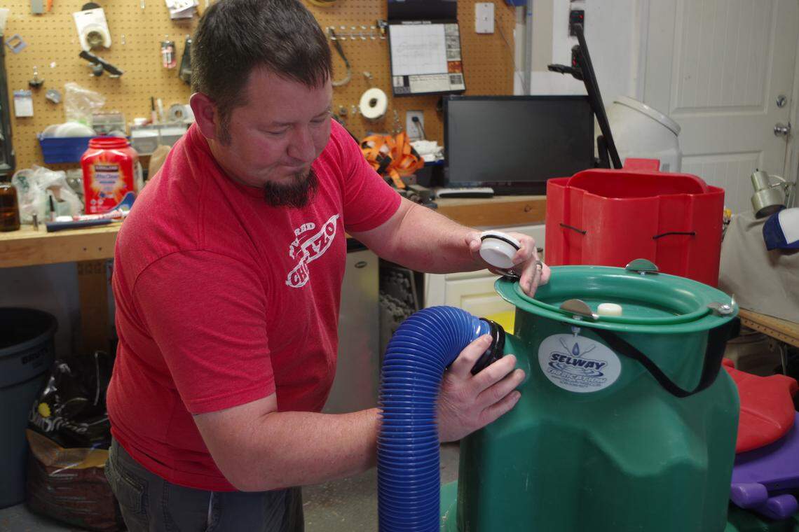 Nate Wilson demonstrates the 3-inch hose hookup for an RV dump on the Selway toilet.