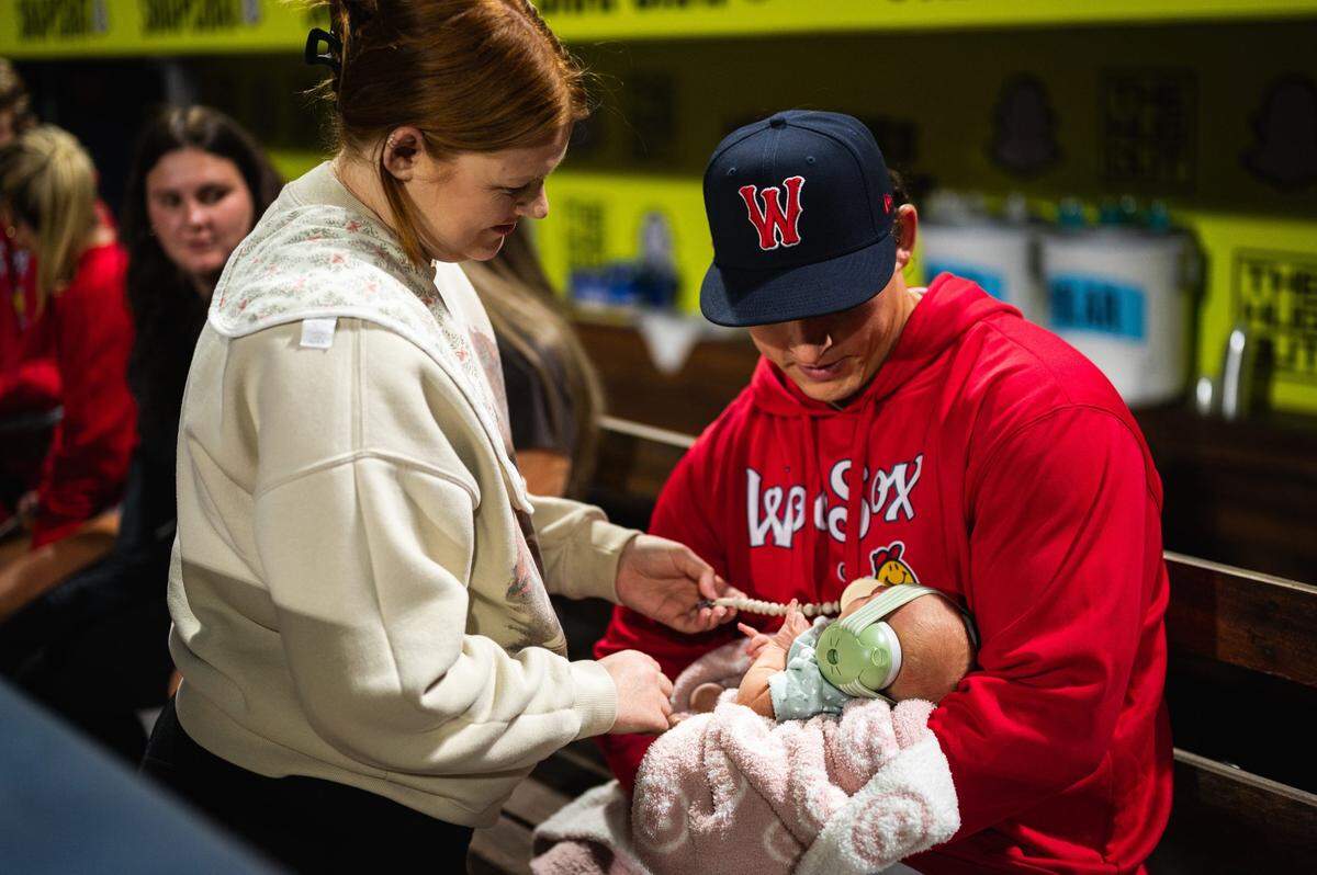 Zach Penrod holds his newborn baby, Noa, and is joined by his wife, Kyla, at Polar Park on Friday night just hours before he received noticed he was being called up to join the Boston Red Sox.