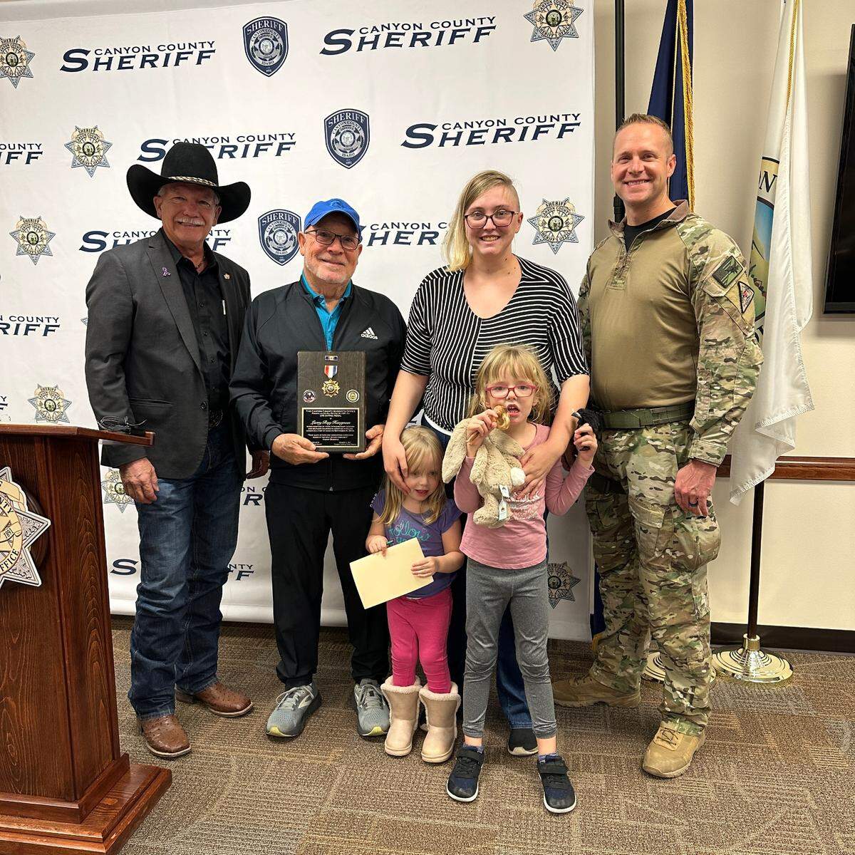 Canyon County Sheriff Kieran Donahue stands with Larry Haughness, 6-year-old Violet Bissel and Bissel’s family.