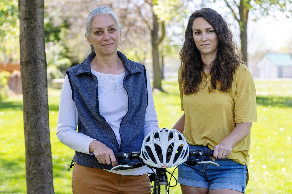 Ross Dodge’s wife, Becky Dodge, left, and daughter Andrea Kingsbury, right, stand with Ross’ bicycle and helmet. Ross Dodge was paralyzed after being hit by a car while biking on his morning commute in 2010 and died in 2021 related to his injuries.