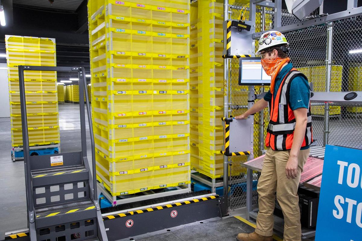 Alex Wright, program manager for robotics development, demonstrates automated couriers at the new Amazon fulfillment center in Nampa.