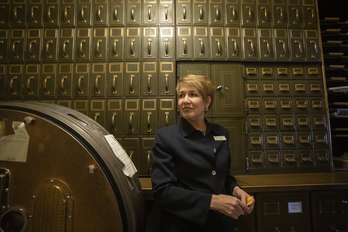 Rows of cabinets that formerly held state financial records flank state Treasurer Julie Ellsworth inside the vault inside her office. Current records are stored below the counter and the door to the vault safe is to the left of her.