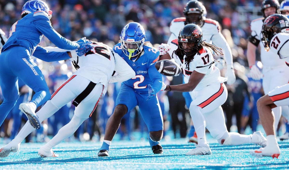 Boise State running back Ashton Jeanty loses a fumble after being hit by Oregon State defensive back Tyrice Ivy, Jr. (left) and defensive back Skyler Thomas (right) during the first half of the game at Albertson’s Stadium in Boise, Idaho. Boise State leads Oregon State 21-7 at the half.