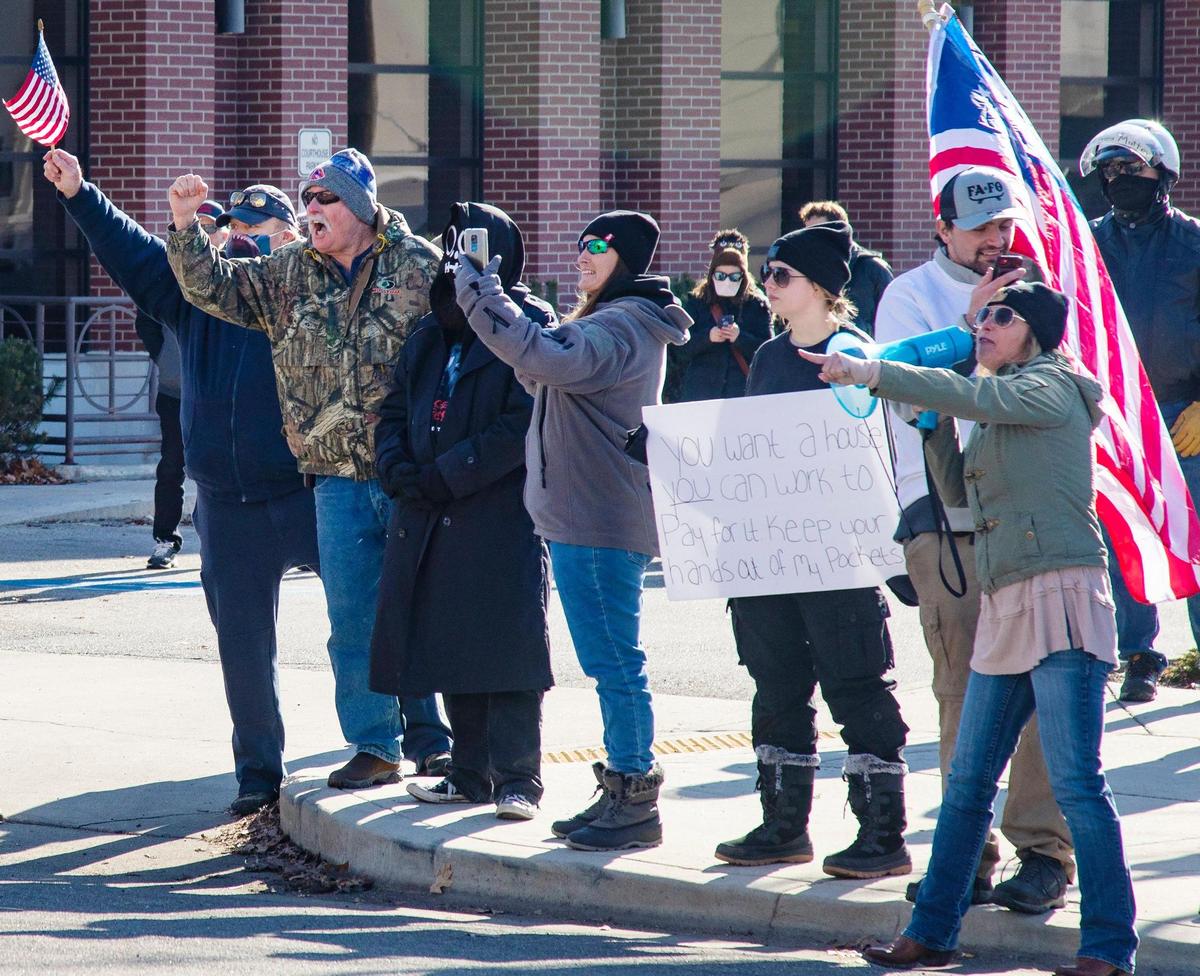 People from the Idaho Liberty Dogs gather across the street from a homeless demonstration to protest the gathering that resembles a tent city in downtown Boise on Saturday, Jan. 29, 2022, outside the former Ada County Courthouse.