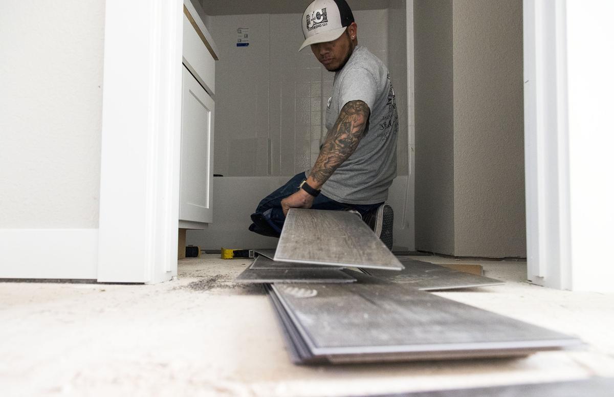 Hundreds of products from China used in construction, including lighting, granite countertops, lighting and appliances, are subject to the 10 percent tariff. Emanuel Del Toro, with J&C Flooring, installs laminate flooring in a CBH Homes house in Meridian.