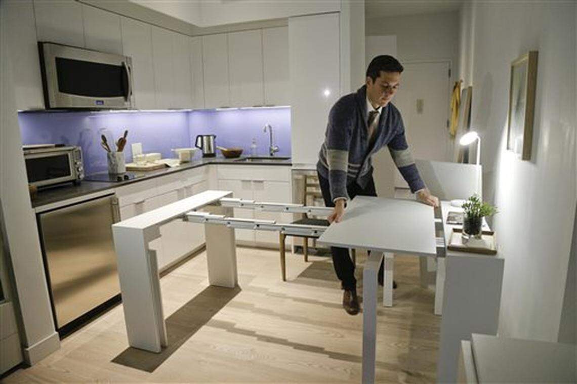 Micro-apartments have been developed in major U.S. and foreign cities in response to high housing costs, and now they are proposed in Boise. The cofounder of a company that partners with developers to build micro-apartments demonstrates a desk, which expands into a dining table that can seat up to 12 people, inside an apartment in New York City.