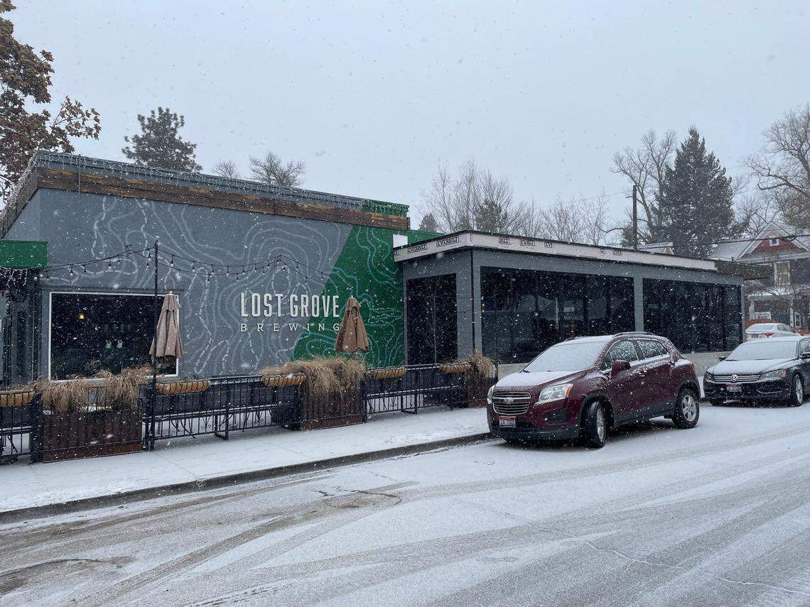 Snow falls outside Lost Grove Brewing in Hyde Park on Thursday.