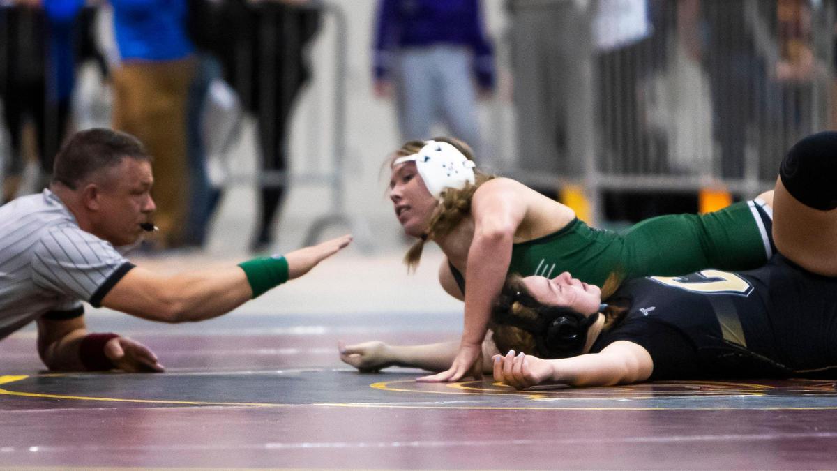 Eagle’s Jordynn LeBeau pins Capital’s Emma Schneider for the district title last week.