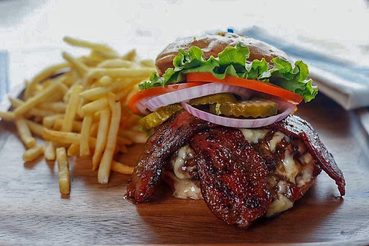 The Bacon Bacon Burger ($13.49) is two four-ounce signature patties stuffed full of house pork belly bacon, topped with bacon jam and melted sharp cheddar cheese, served on a toasted brioche bun with lettuce, pickle, tomato, onion and Hog Sauce.