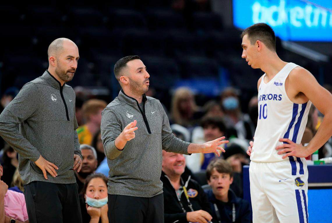 Coaches Seth Cooper, left, and Jacob Rubin, center, talk with Justinian Jessup in the first half as the Golden State Warriors played the Los Angeles Lakers during summer league action at the California Classic at the Chase Center on July 3 in San Francisco.