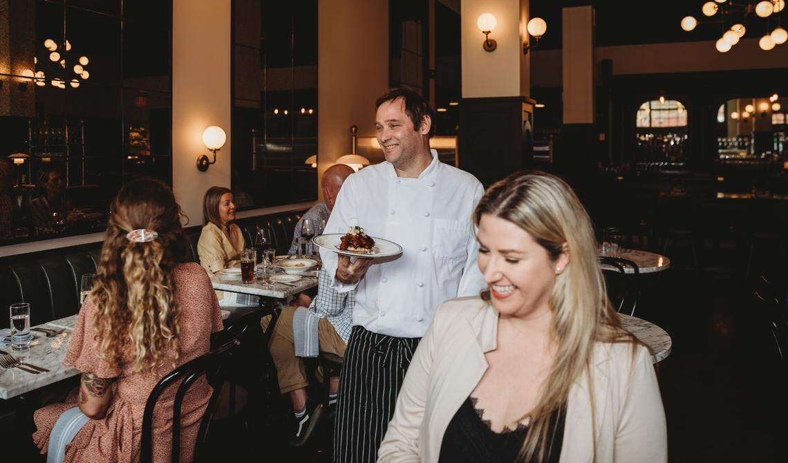 Cal Elliott, chef and co-owner of The Avery Hotel, carries a plate in his downtown Boise restaurant.