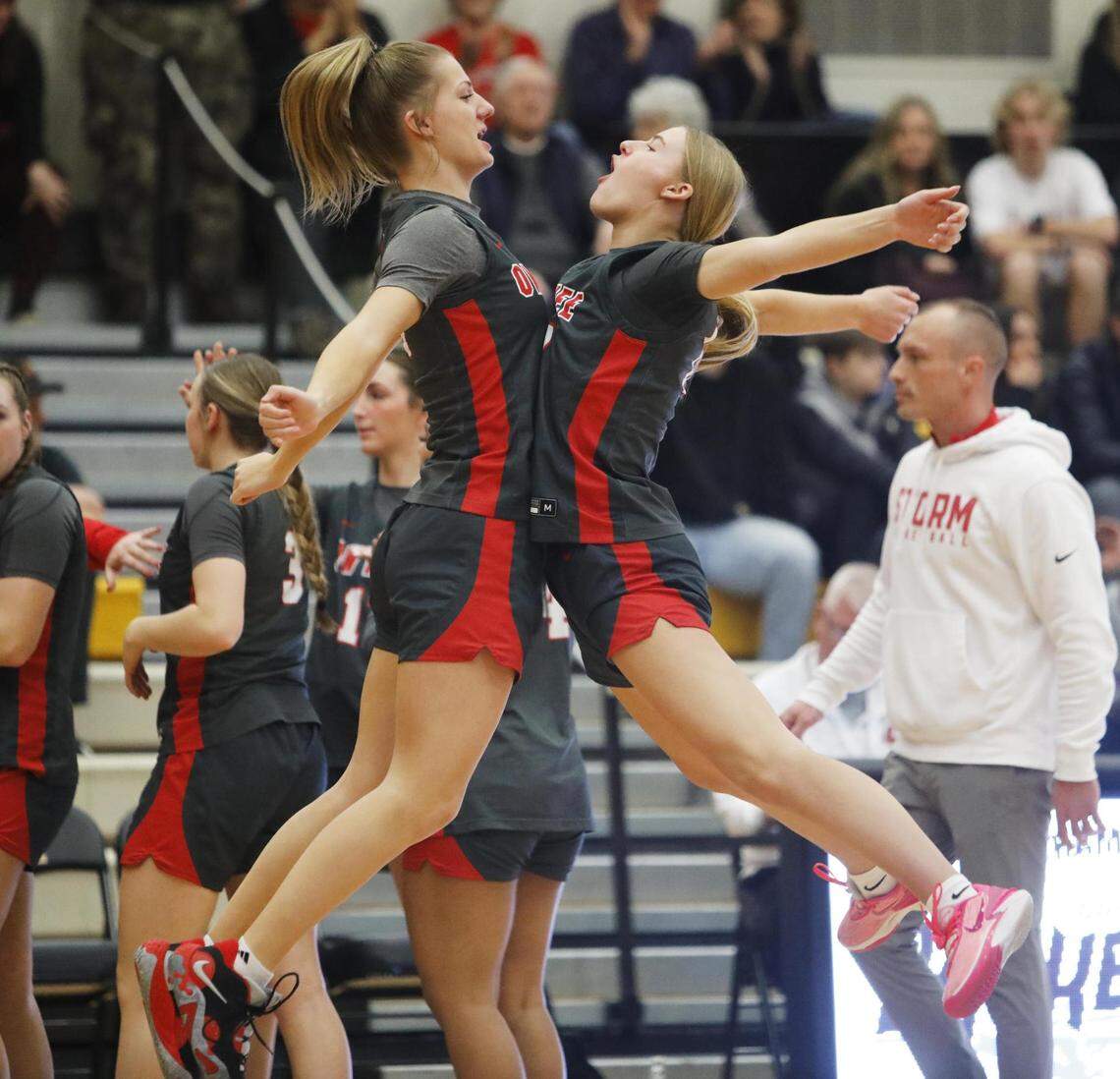 Owyhee’s Audrey McKenna, left, and Adelynn Wright celebrate after the Storm beat Rocky Mountain 43-37 in the 5A girls basketball state tournament consolation final Saturday at Bishop Kelly High.